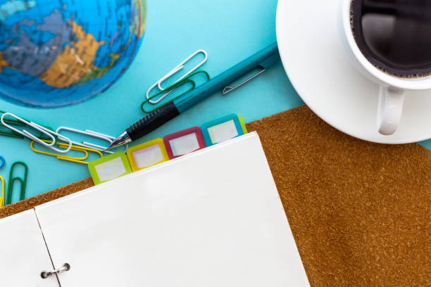 istock Blank page planner with mechanical pencil and black coffee on blue background in top view 1426137547