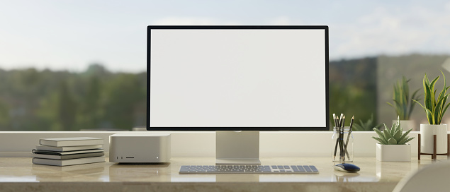 Maqueta de pantalla de computadora en mesa de mármol blanco contra la ventana con vista a la montaña photo