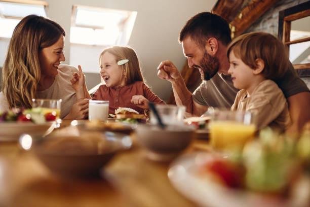 Cheerful family talking during breakfast at dining table.