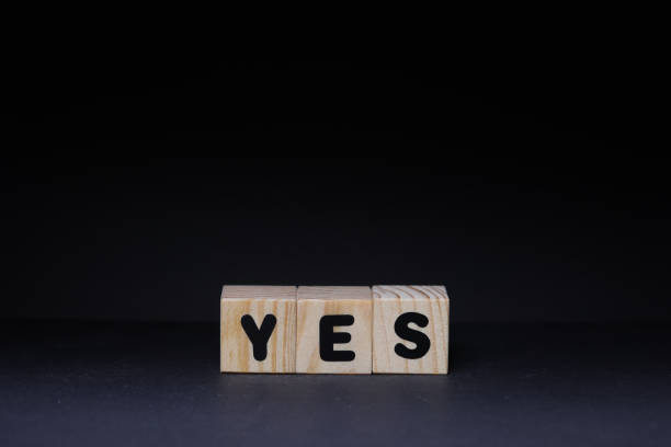 istock Yes word on wooden cubes on black background 1426142392