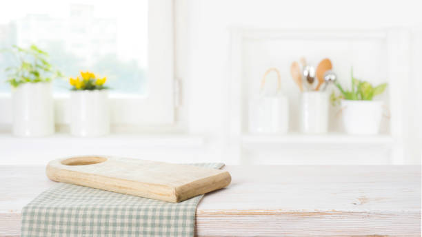 istock Wooden cutting board stand with tablecloth on kitchen table background 1426144135