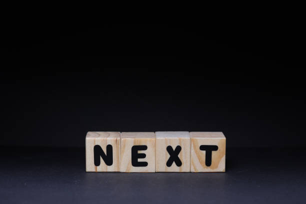 istock Next word on wooden cubes on black background 1426144626