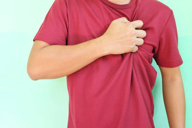heart pain, attack, ache, and heartburn concept. young asian man grabbing or holding his chest area. - chest pain imagens e fotografias de stock
