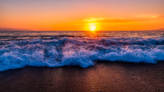 A Sunset Back Lit Ocean Wave Is Breaking On The Beach Shore In High Resolution