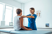 istock Teenage boy sitting on massage table and getting physical therapy 1426153523
