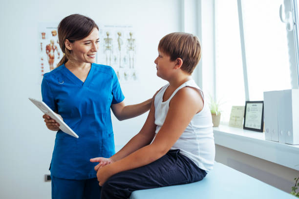 junge kinderarzt genießt gespräch mit eltern - doctors office examination room examination table office stock-fotos und bilder