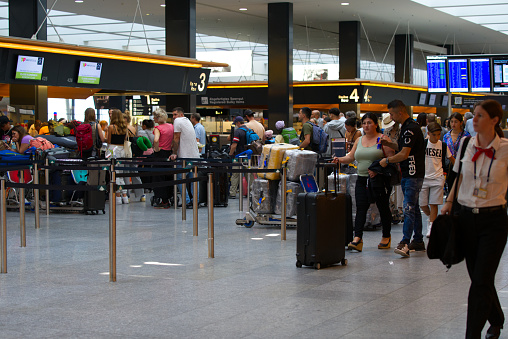 Flight passengers with luggage at Zurich Airport for check in on a sunny summer day. Photo taken July 15th, 2022, Zurich Airport, Switzerland.