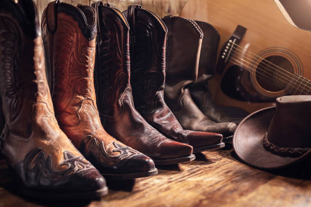 festiwal muzyki country koncepcja koncertu na żywo z gitarą akustyczną, kowbojskim kapeluszem i trzema parami butów - cowboy hat wild west hat wood zdjęcia i obrazy z banku zdjęć