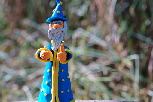 A toy wizard on a colored background. Fabulous scenery.
