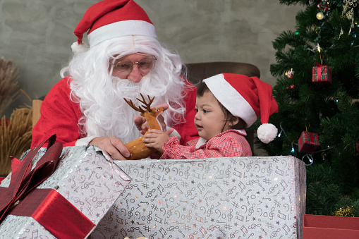 Little girl childhood cute happy smiling delighted with a gift box from Uncle Santa Claus. festival celebration. Merry Christmas happy new year concept