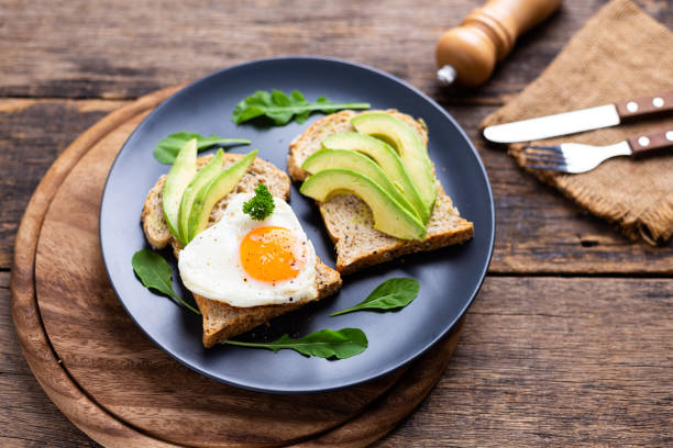 istock Avocado Sandwich with Fried Egg On black plate on the wooden table 1426179018