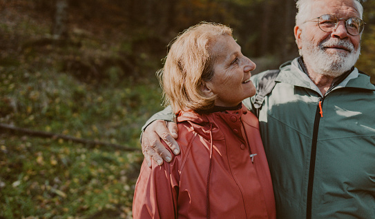 Photo of an elderly couple during a pleasant autumn walk, down the forest