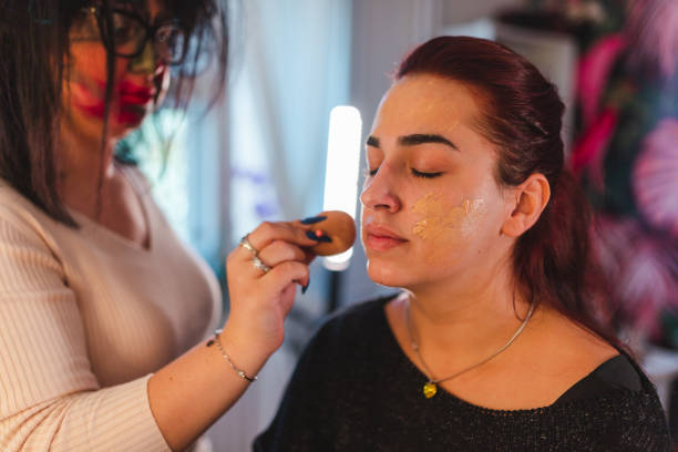 istock Young woman getting her Halloween makeup done by a professional makeup artist 1426181082