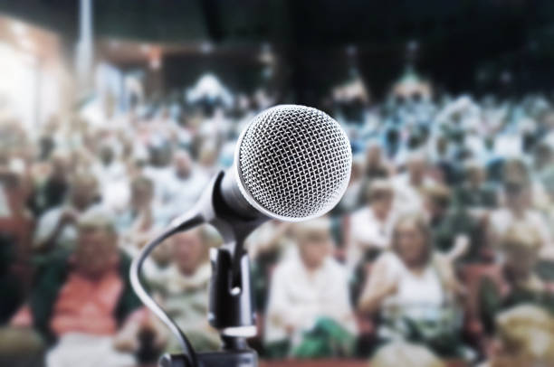 mikrofon wokalny czekający na mówcę, piosenkarza lub aktora w zatłoczonym teatrze, z niewyraźną publicznością czekającą na pokaz - dynamic microphone zdjęcia i obrazy z banku zdjęć