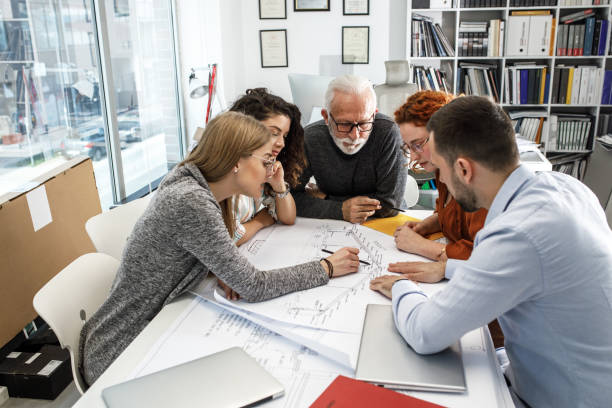 istock Working day in a design studio. Group of designers and architects on meeting. 1426193121
