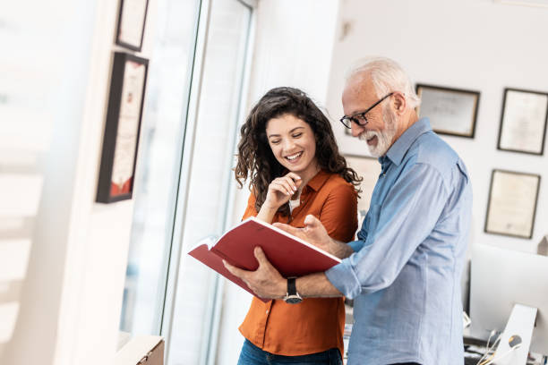 istock Two coworkers standing at the office and examining a new catalog. 1426193250