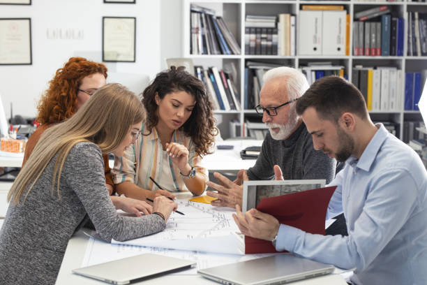 Working day in a design studio. Group of designers and architects on meeting. stock photo