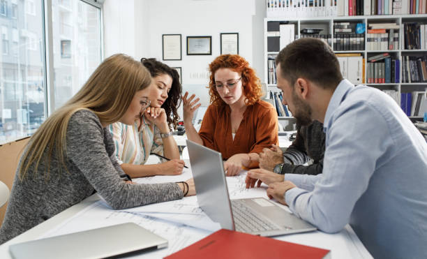 istock Working day in a design studio. Group of designers and architects on meeting. 1426193764