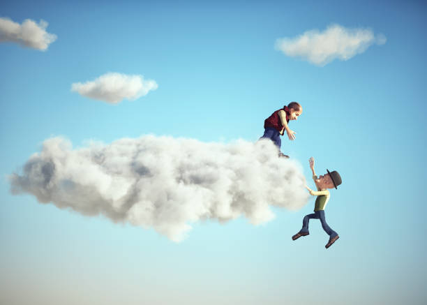 istock Man helping his partner to get over the clouds edge 1426204337
