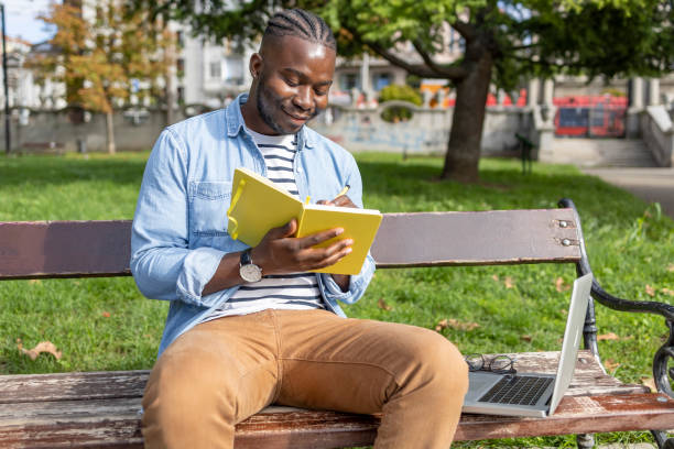 istock Man studying in a park satisfied by his progress 1426204838