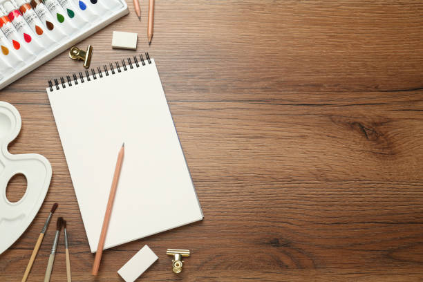 istock Flat lay composition with sketchbook and drawing tools on wooden table, space for text 1426207255