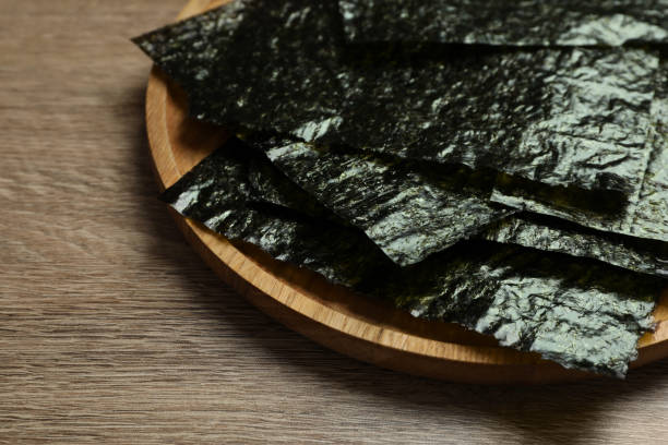 istock Plate with dry nori sheets on wooden table, closeup 1426207566