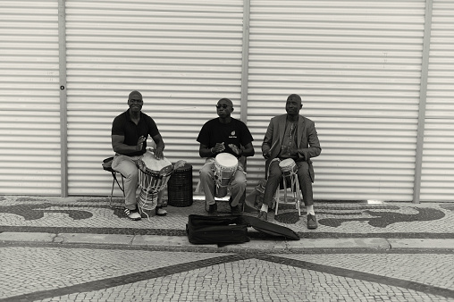 Lisbon, Portugal - July 2, 2022: A trio of african street musicians perfoms at the Rua Augusta street in Lisbon downtown.