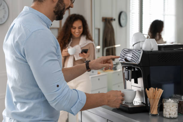 istock Man talking with colleague while using modern coffee machine in office, closeup 1426212286