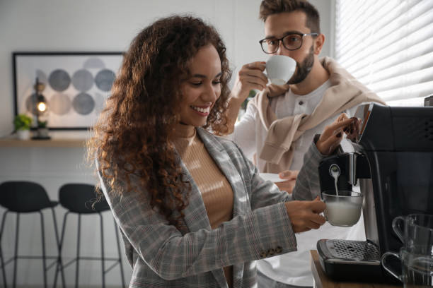 afroamerykanka przygotowująca świeżą aromatyczną kawę nowoczesnym ekspresem w biurze - coffee contemporary arabica scented zdjęcia i obrazy z banku zdjęć