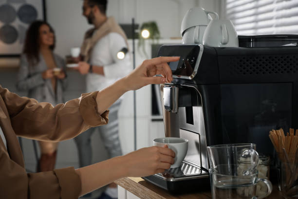 donna che prepara il caffè aromatico fresco con la macchina moderna in ufficio, primo piano - espresso coffee cafe making foto e immagini stock
