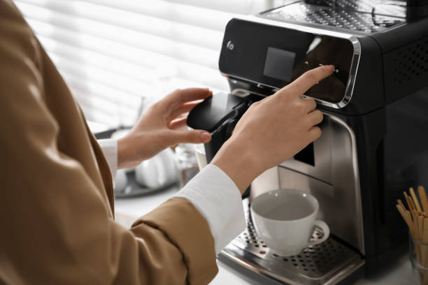 istock Young woman preparing fresh aromatic coffee with modern machine in office, closeup 1426212413