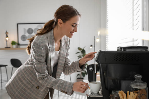istock Young woman preparing fresh aromatic coffee with modern machine in office 1426212506