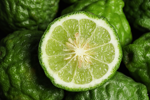 Whole and cut ripe bergamot fruits as background, top view