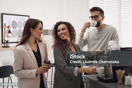 istock African American woman talking with colleagues while using modern coffee machine in office 1426212875