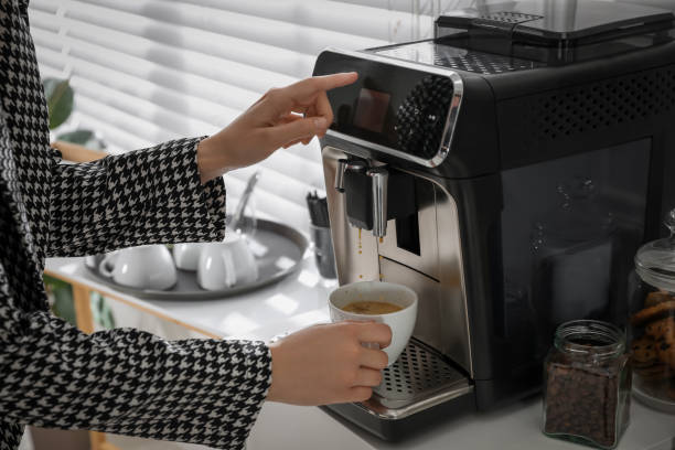 istock Young woman preparing fresh aromatic coffee with modern machine in office, closeup 1426213484