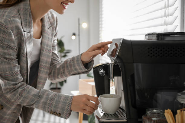 istock Young woman preparing fresh aromatic coffee with modern machine in office, closeup 1426213580