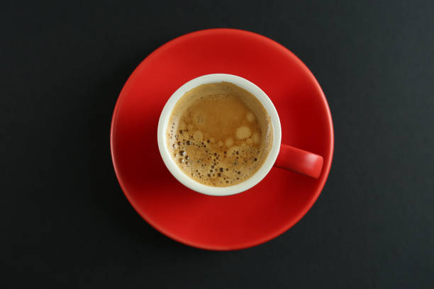 istock Cup of tasty coffee on black background, top view 1426214093
