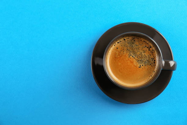 istock Cup of tasty coffee on light blue background, top view. Space for text 1426214122