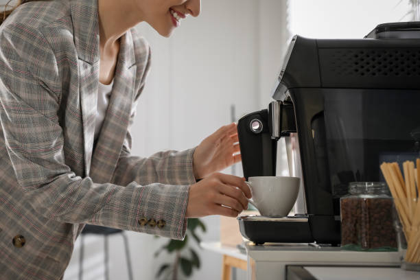 istock Young woman preparing fresh aromatic coffee with modern machine in office, closeup 1426214144