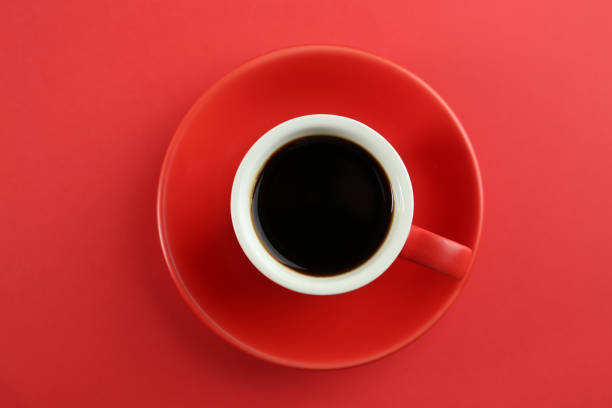 istock Cup of tasty coffee on red background, top view 1426214198