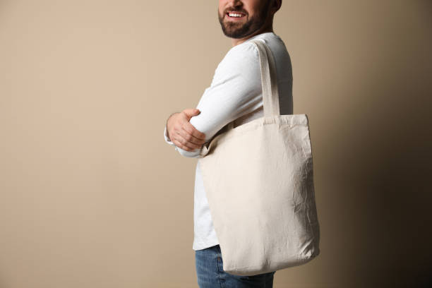 istock Happy young man with eco bag on beige background, closeup 1426214862