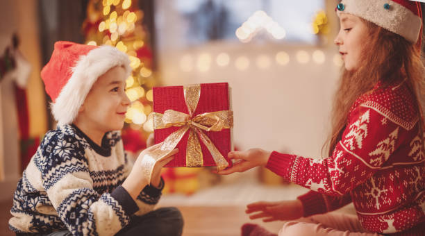 istock Boy giving red present box to cute girl 1426216355