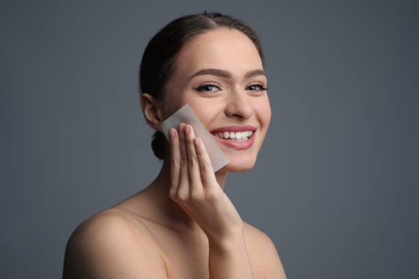 istock Beautiful woman using mattifying wipe on grey background 1426216505