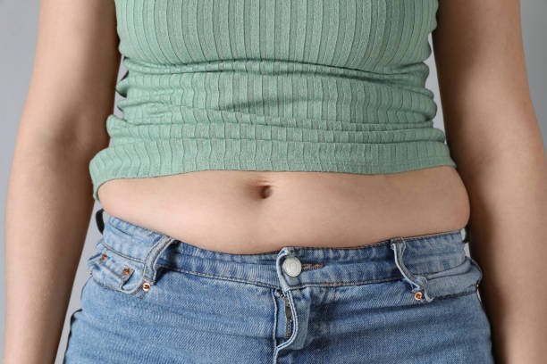 istock Woman wearing tight clothes on light grey background, closeup. Overweight problem 1426216552