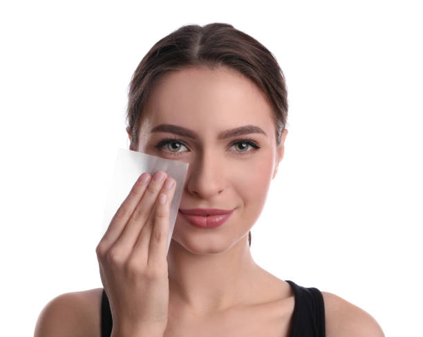 istock Beautiful woman using mattifying wipe on white background 1426216557