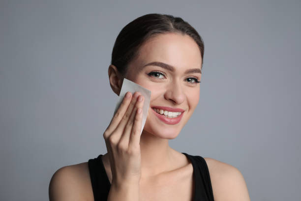 istock Beautiful woman using mattifying wipe on grey background 1426216633