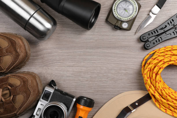 istock Frame of different camping equipment on wooden background, flat lay. Space for text 1426216898