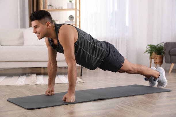 istock Handsome man doing plank exercise on yoga mat at home 1426216925