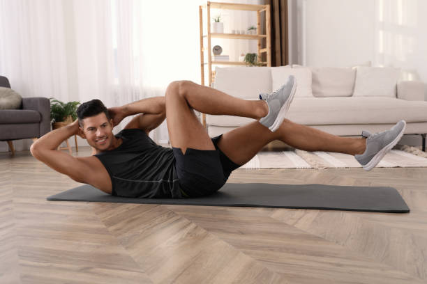 istock Handsome man doing abs exercise on yoga mat at home 1426216942