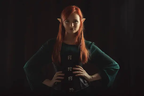 Beautiful redhead elf girl on black background